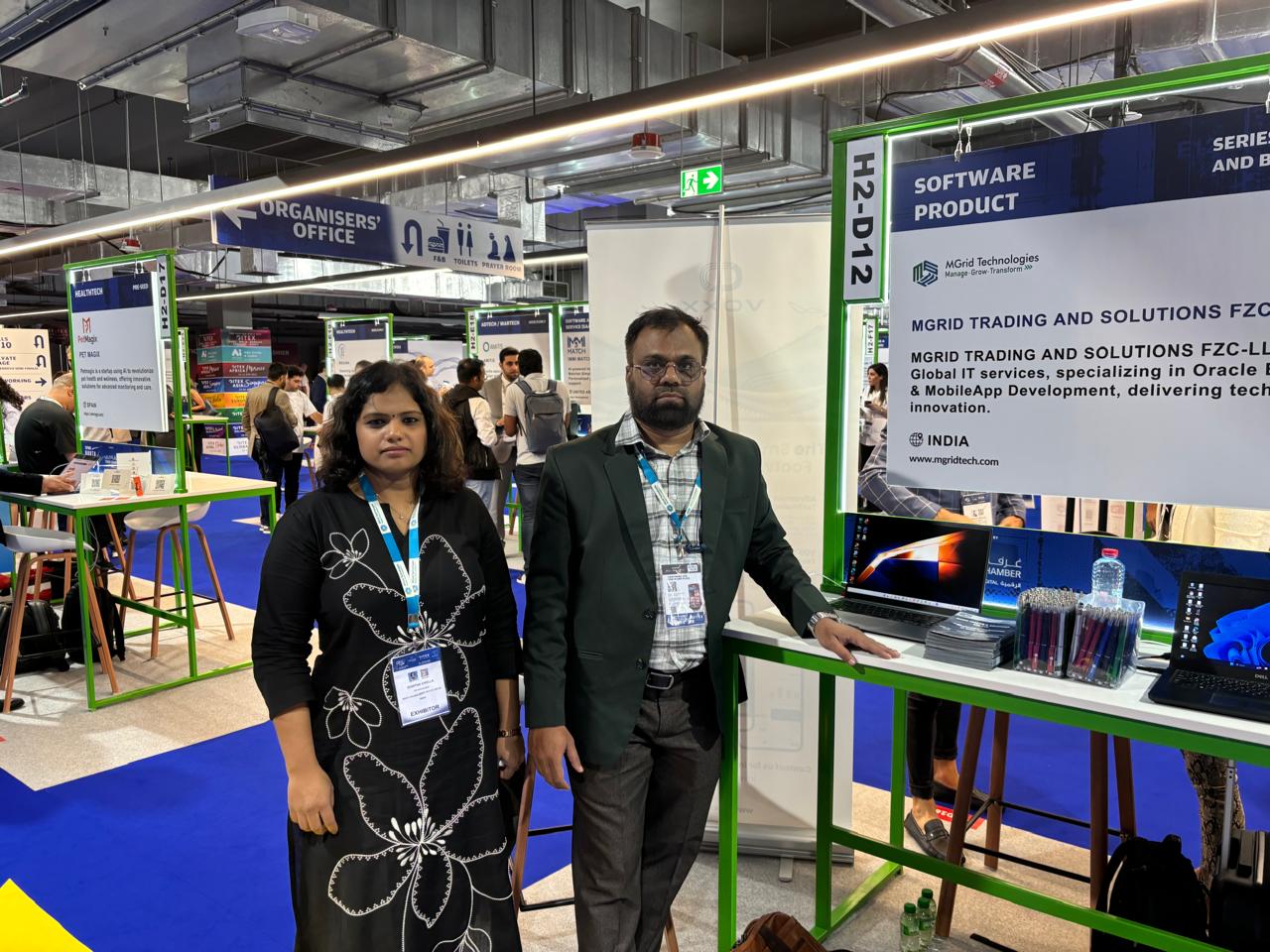 Two people at the MGrid Technologies stand at GITEX Global 2025